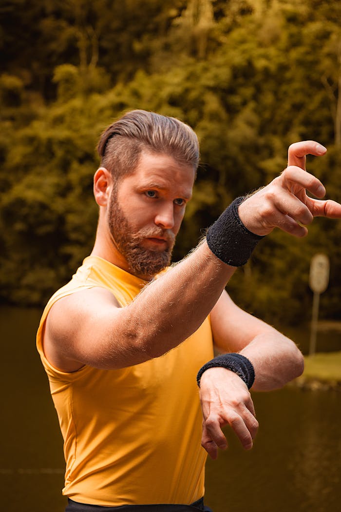 services-04 A man in sportswear practicing martial arts poses in a park setting.