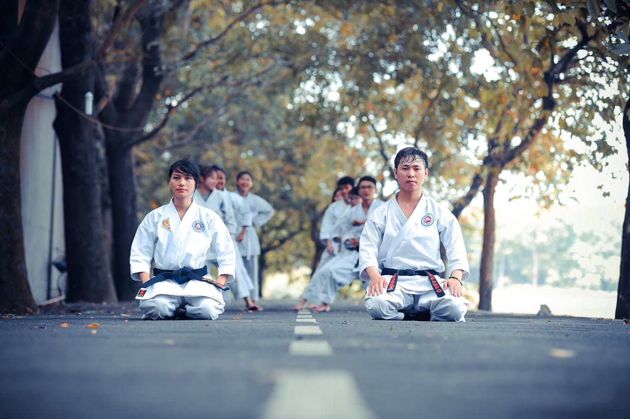 services-01 Karate practitioners performing martial arts training outdoors on a sunny day.